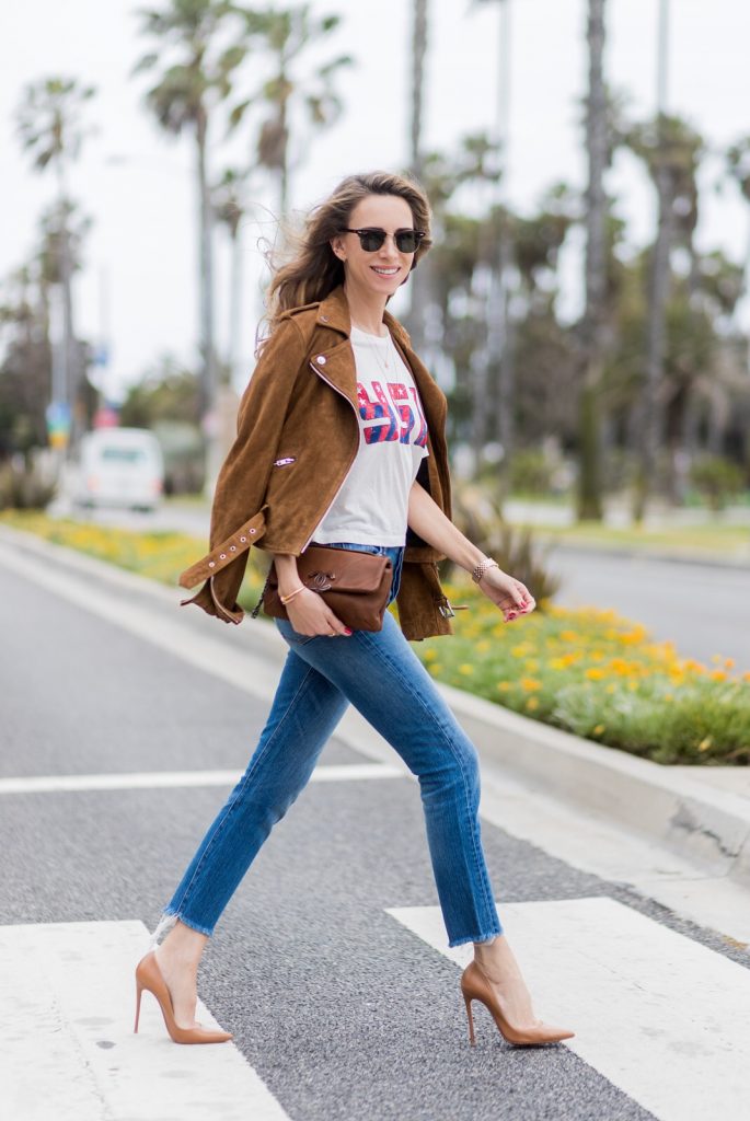 Model and fashion blogger Alexandra Lapp wearing a suede biker Jacket from Tigha, Wedgie Icon Fit jeans, slim fit in dark blue by Levi's, washed rose cotton YSL USA cropped T-shirt from Saint Laurent featuring a ribbed round neck, dropped shoulders, short sleeves, a print to the front, a straight hem and a loose fit, Christian Louboutin pumps 'So Kate' in brown cognac, Chanel bag 2.55 with a big Coco Chanel Logo, Ray Ban Clubmaster sunglasses, IWC Da Vinci Automatic 36 watch in 18-carat red gold with diamonds and jewelry from AYS (Art Youth Society) on April 19, 2017 in Los Angeles, California.
