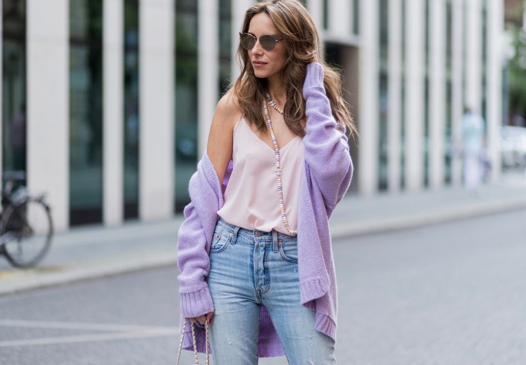 Alexandra Lapp wearing a pastel purple look, a purple cashmere cardigan by Heartbreaker, a rose tank top in silk from Jadicted, a high waist, non-strech denim, five-pocket 501 skinny jeans from Levis, a candy necklace from Chanel supermarket collection in pastel tones, a Chanel perfume bottle bag in plexiglass and a golden chain with white leather, Christian Louboutin pumps Feerica with nude mesh upper embedded with a Swarovski crystal degrade and Karl Lagerfeld cat-eye sunglasses in the shape of cat ears during the Mercedes-Benz Fashion Week Berlin Spring/Summer 2018 on July 7, 2017 in Berlin, Germany.