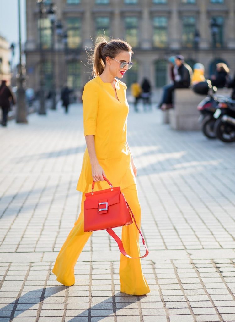 Alexandra Lapp wearing taroni silk pants & a tunic in yellow from Talbot & Runhof, small Viv Cabas in orange with shoulder strap, mirrored sunglasses from Le Specs and Christian Louboutin So Kate Pumps is seen on February 28, 2018 in Paris, France.